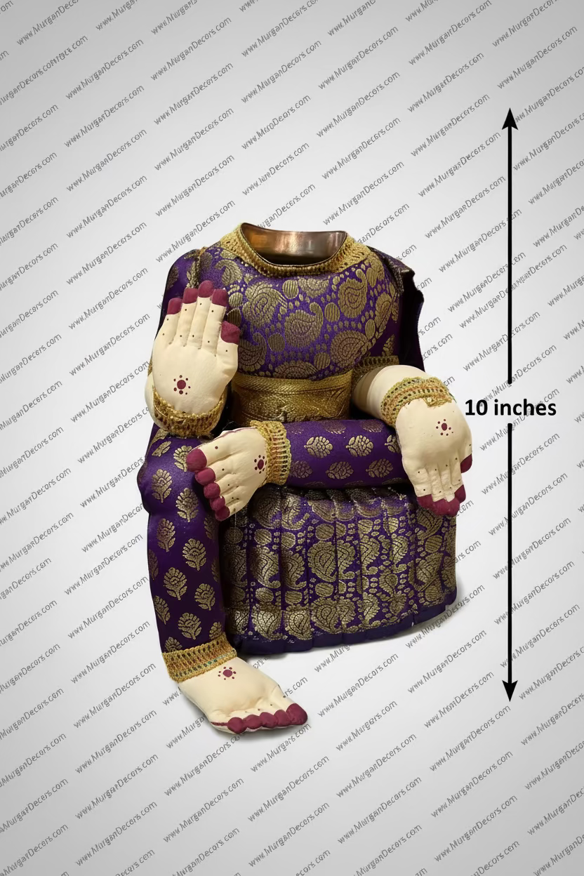 A traditional Indian deity idol, likely Goddess Lakshmi, featuring a purple and gold brocade-patterned body, seated pose, and cream-colored hands with painted fingernails and red markings, surrounded by plastic wrapping and brass vessels in a shop setting. Shop Varalakshmi amman Idol body with Purple silk saree for Decoration in USA at MuruganDecors